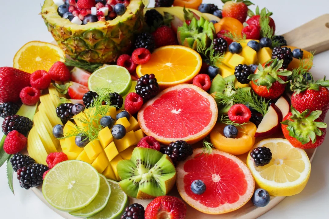 barevna smes exotickeho ovoce na tacu ananas kiwi pomeranc jahody maliny a dalsi zdrave obcerstveni