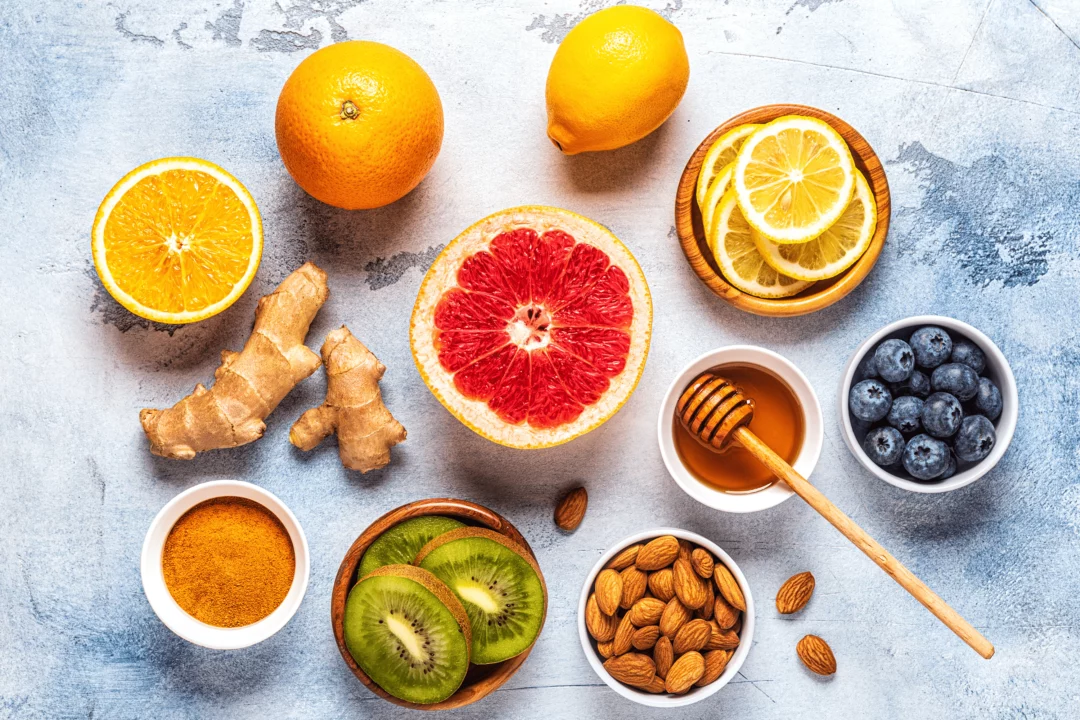 cerstve citrusy kiwi zazvor boruvky med mandle a kurkuma na svetle desce jako zdrave ingredience pro imunitu