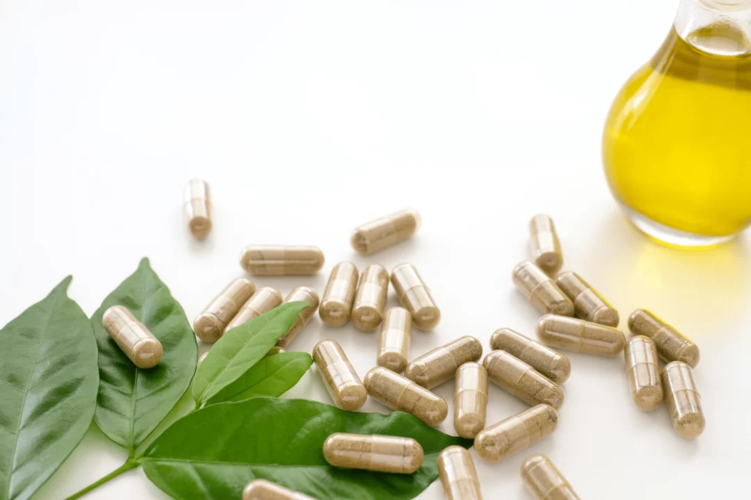 bylinne doplnky v kapslich vedle zelenych listu a oleje prirodni zdravi a wellness koncept