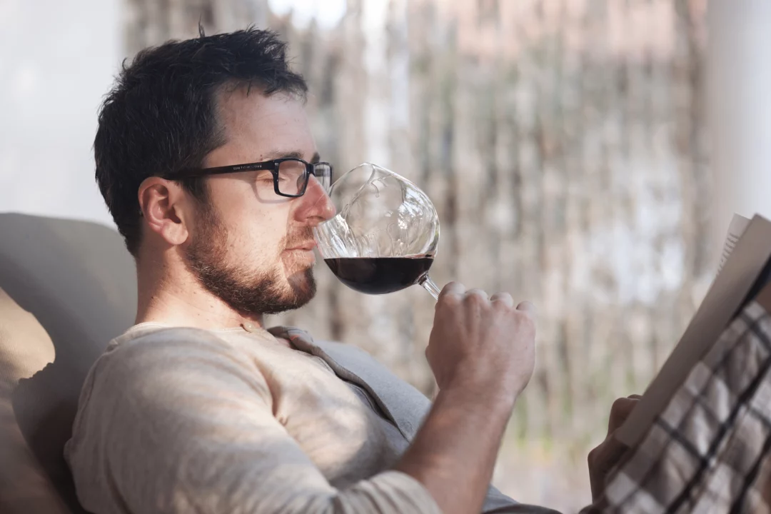 muz relaxuje na slunci popiji cervene vino a cte knihu moment klidu a pohody s oblibenou literaturou