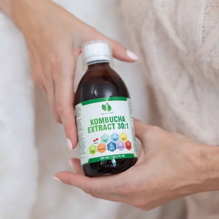 Ruce drží láhev s nápisem Kombucha Extract 30:1. Efektivní doplněk pro zdraví, 300 ml balení.