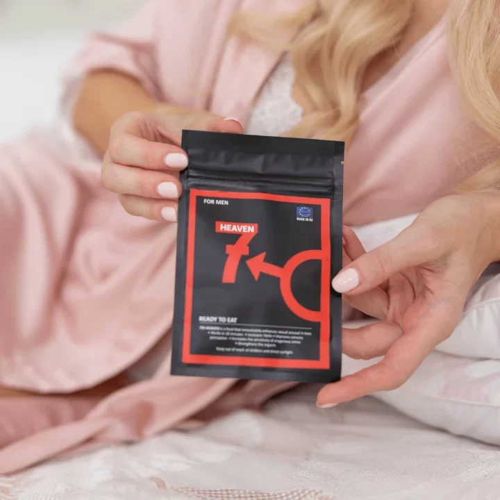 Žena v růžovém županu drží balení produktu Heaven for Men na bílé posteli. Produkt je označen jako Ready to Eat.